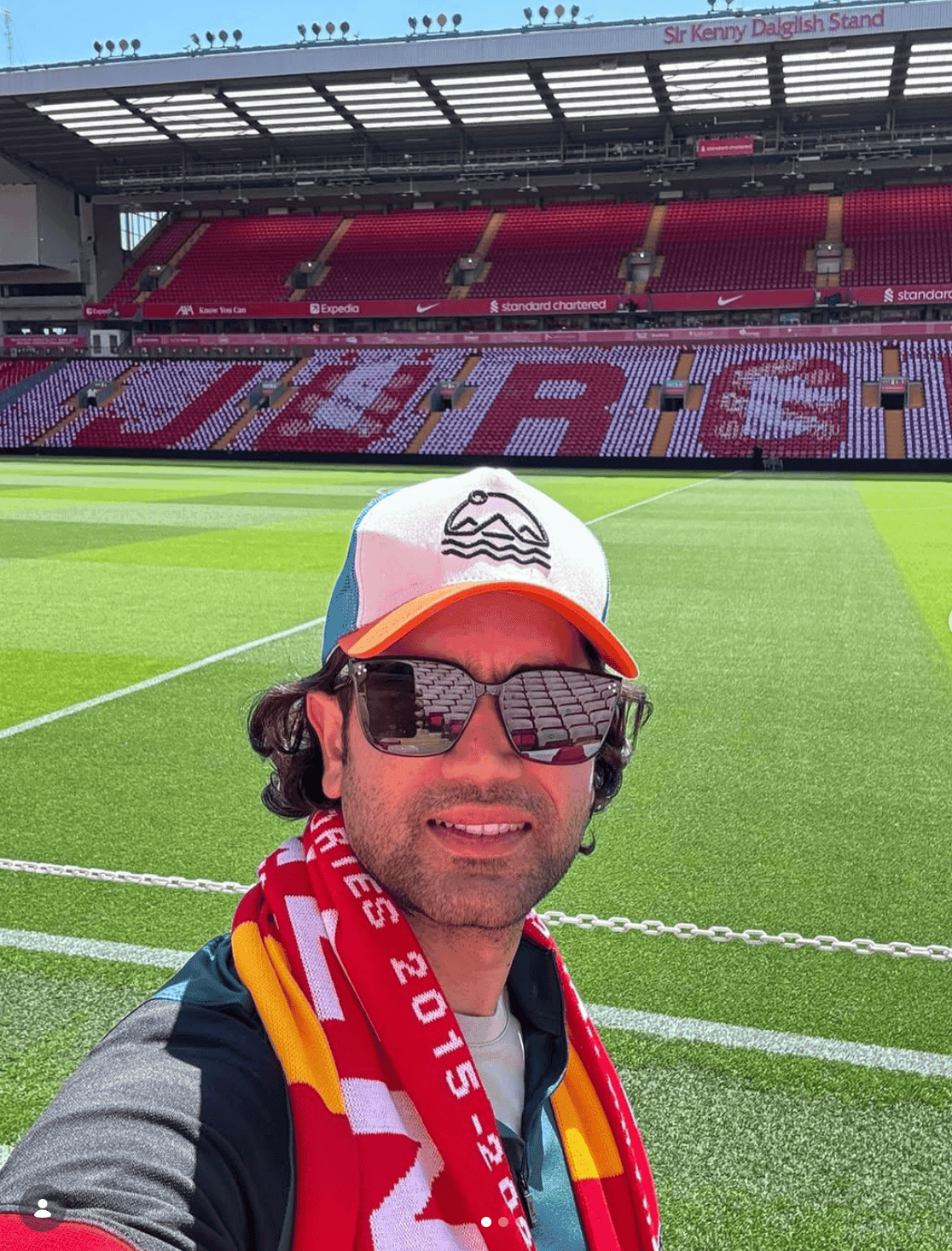 A pilgrimage to Anfield, scarf and all — some caps are made for football grounds, not trailheads.