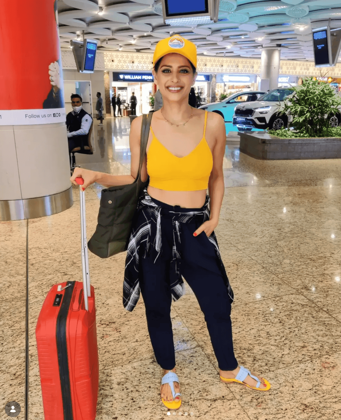 Red suitcase, yellow cap, that specific kind of airport energy right before a trip actually starts.