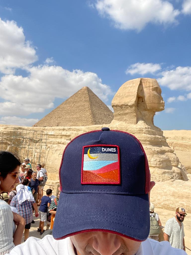 Pyramids of Giza in the background, cap in the foreground, tourists everywhere in between.