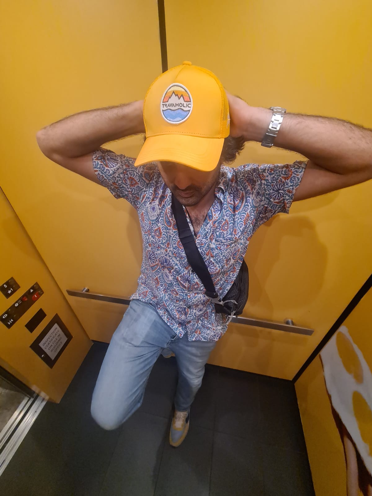 Adjusting the cap in an elevator mirror before heading back out — the small rituals of a trip.